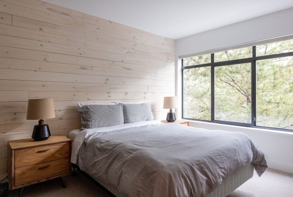 Renovated bedroom with modern finishes, neutral tones, and large window, showcasing Revere Homes' custom home renovation work in BC.